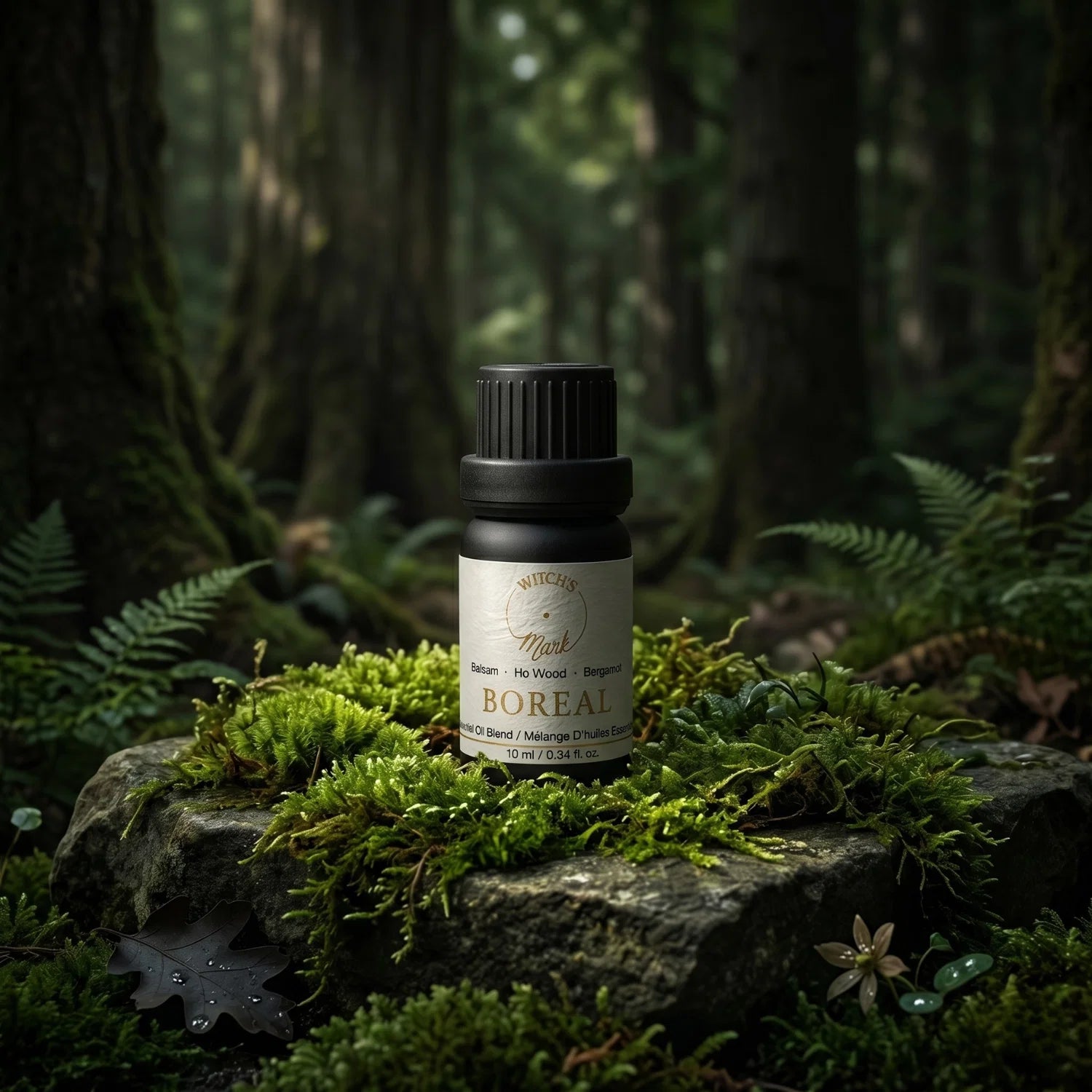 Boreal essential oil blend bottle in the middle of a forest scene.