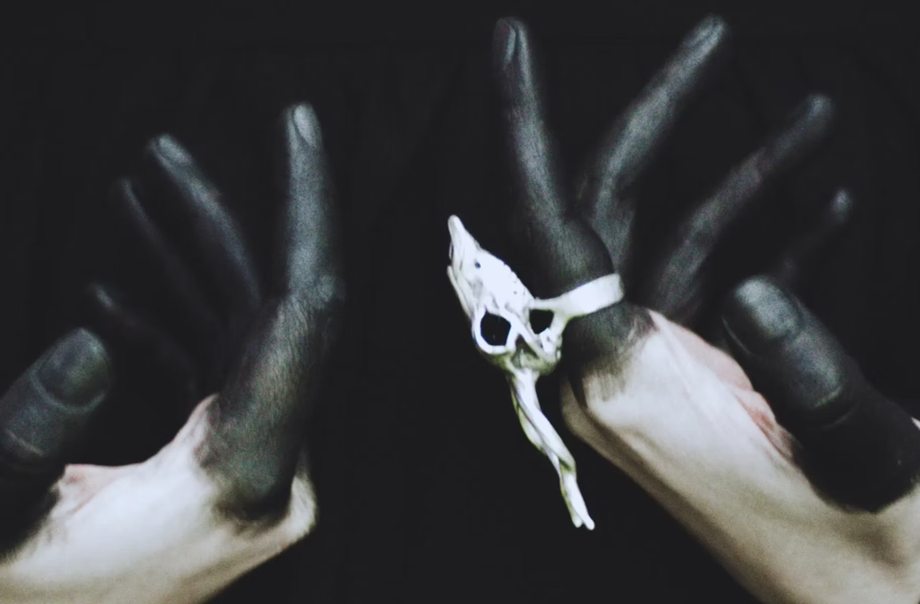 Two witchy hands with fingers painted black in a ritualistic shot